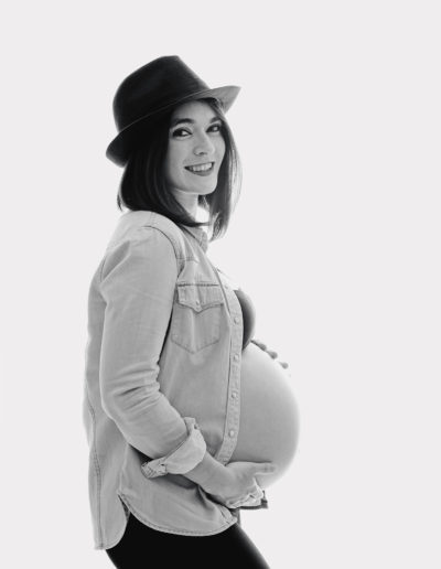 black & white picture of an expectant mum smiling lovingly during a photo shoot norwich