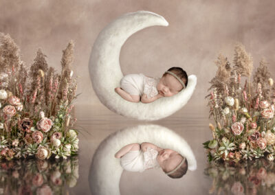 gorgeous newborn girl with flowers on a moon set