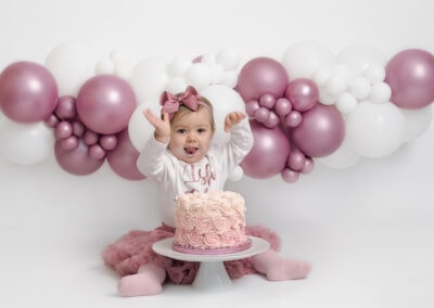 baby girl having fun during her 1st birthday cakesmash