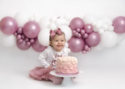 happy baby girl during her 1st birthday cake smash